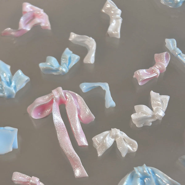 Colorful stacked diamond nail decorations on a reflective surface