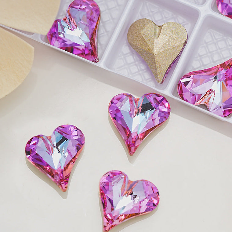 Heart-shaped crystal decorations on a light surface with a box in the background.